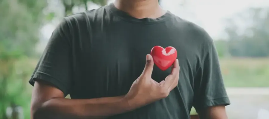 Man holding a heart at his chest.